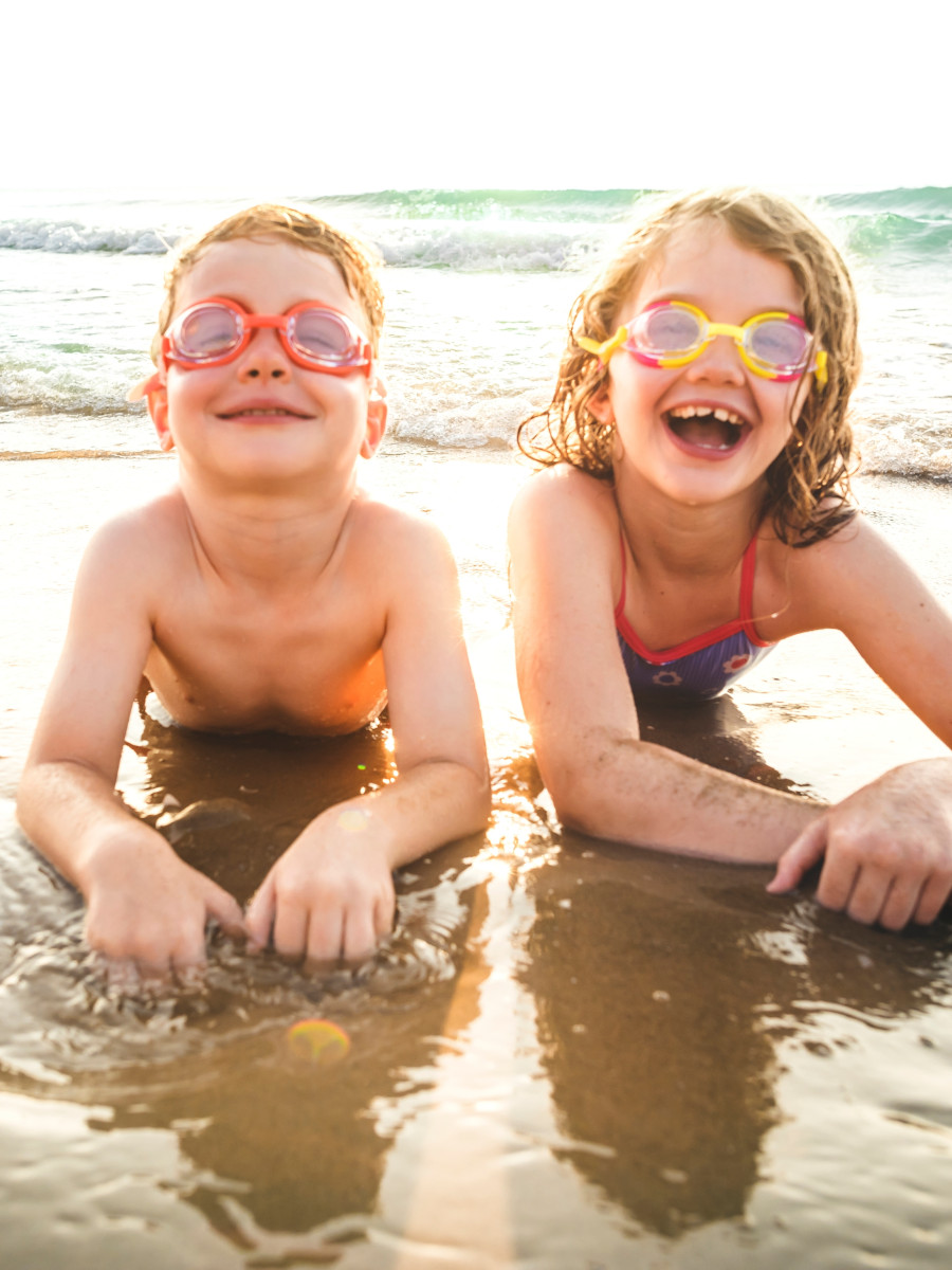 Little brother and sister having fun on the beach